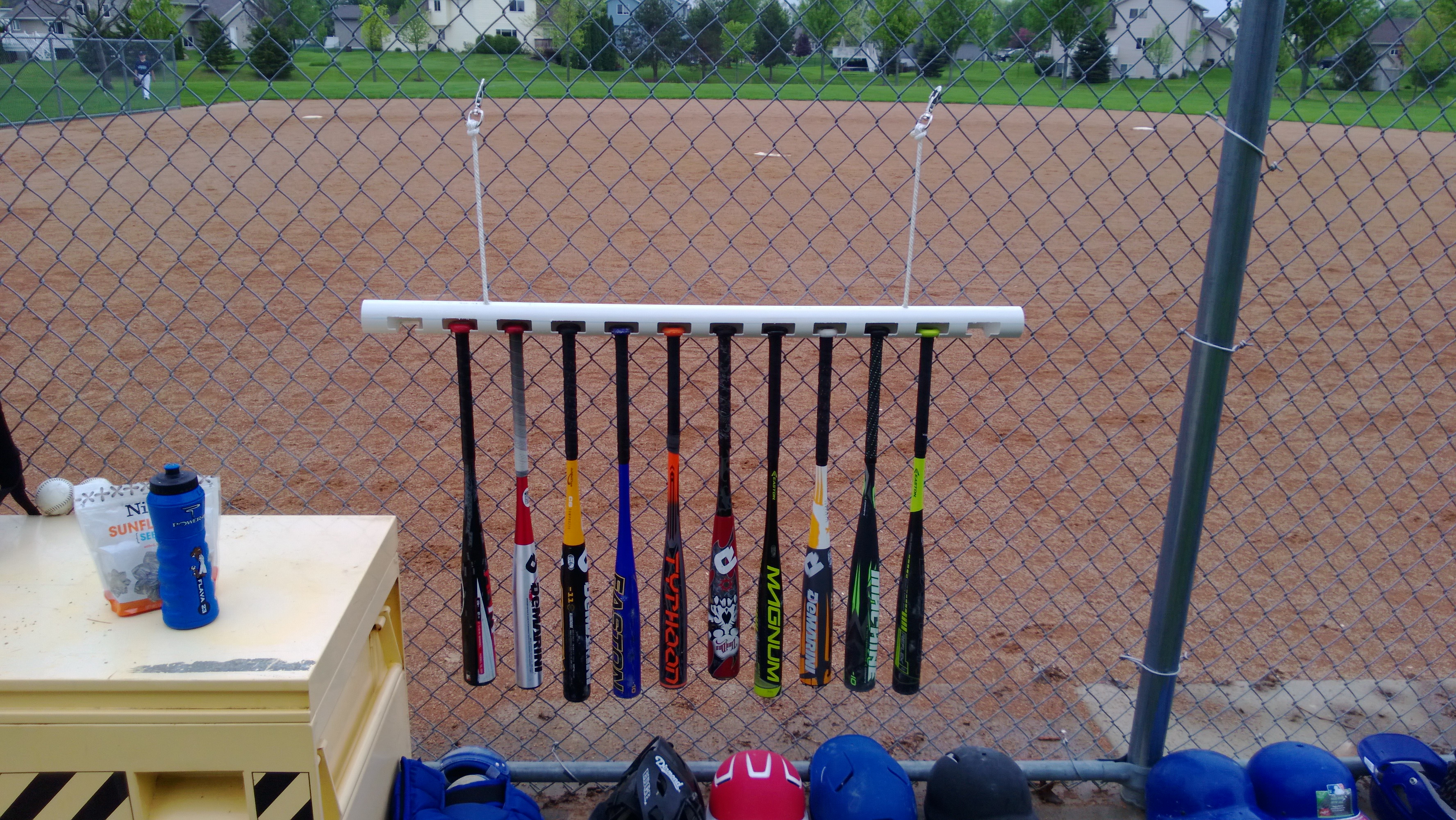 baseball bat holder on wire fence around baseball field
